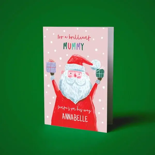 Personalised Christmas card featuring an illustrated Santa holding presents on a pink background with festive snowfall details.